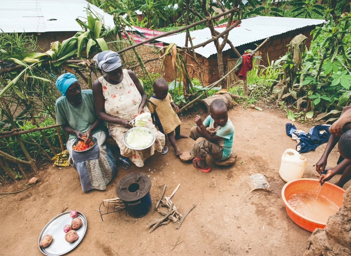 A rural family in Nigeria utilizing an SSM efficient cookstove solution for healthier, clean outdoor food preparation.