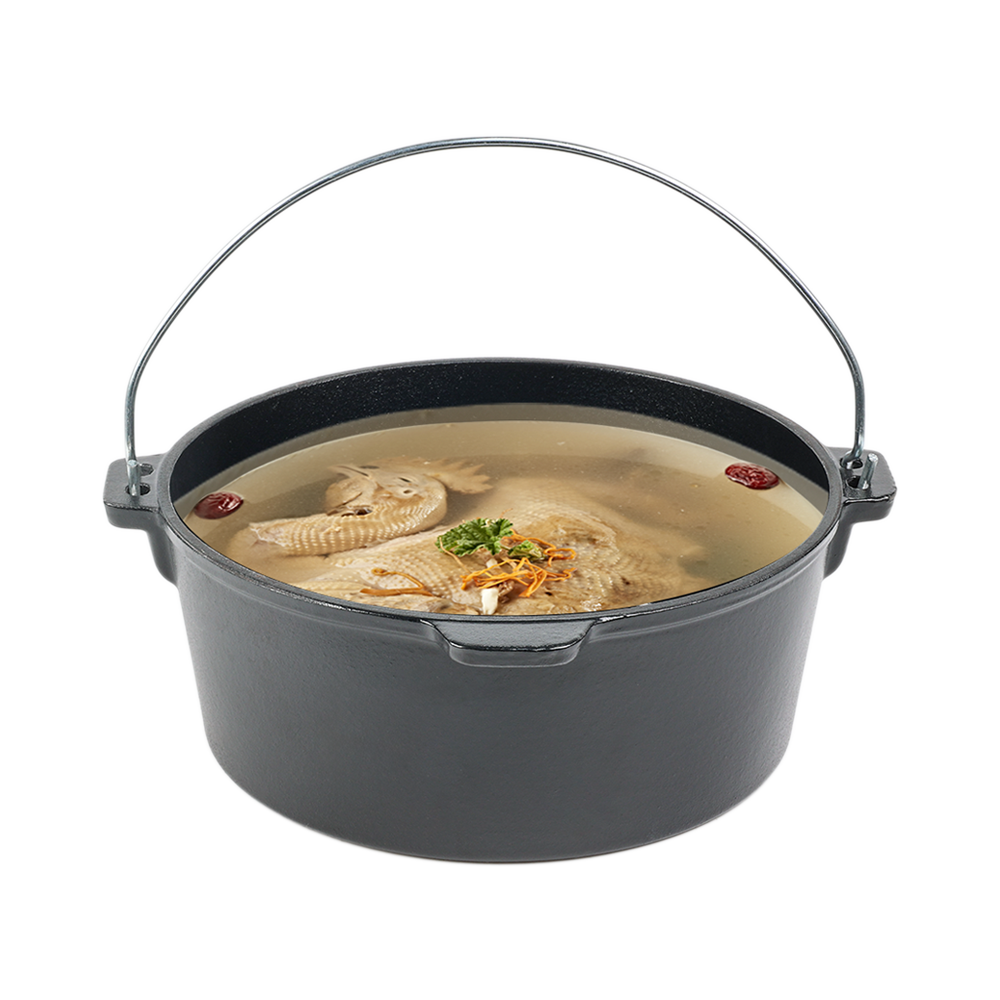 A whole chicken soup with herbs simmering inside a deep cast iron Dutch oven pot, showcasing even heat distribution.